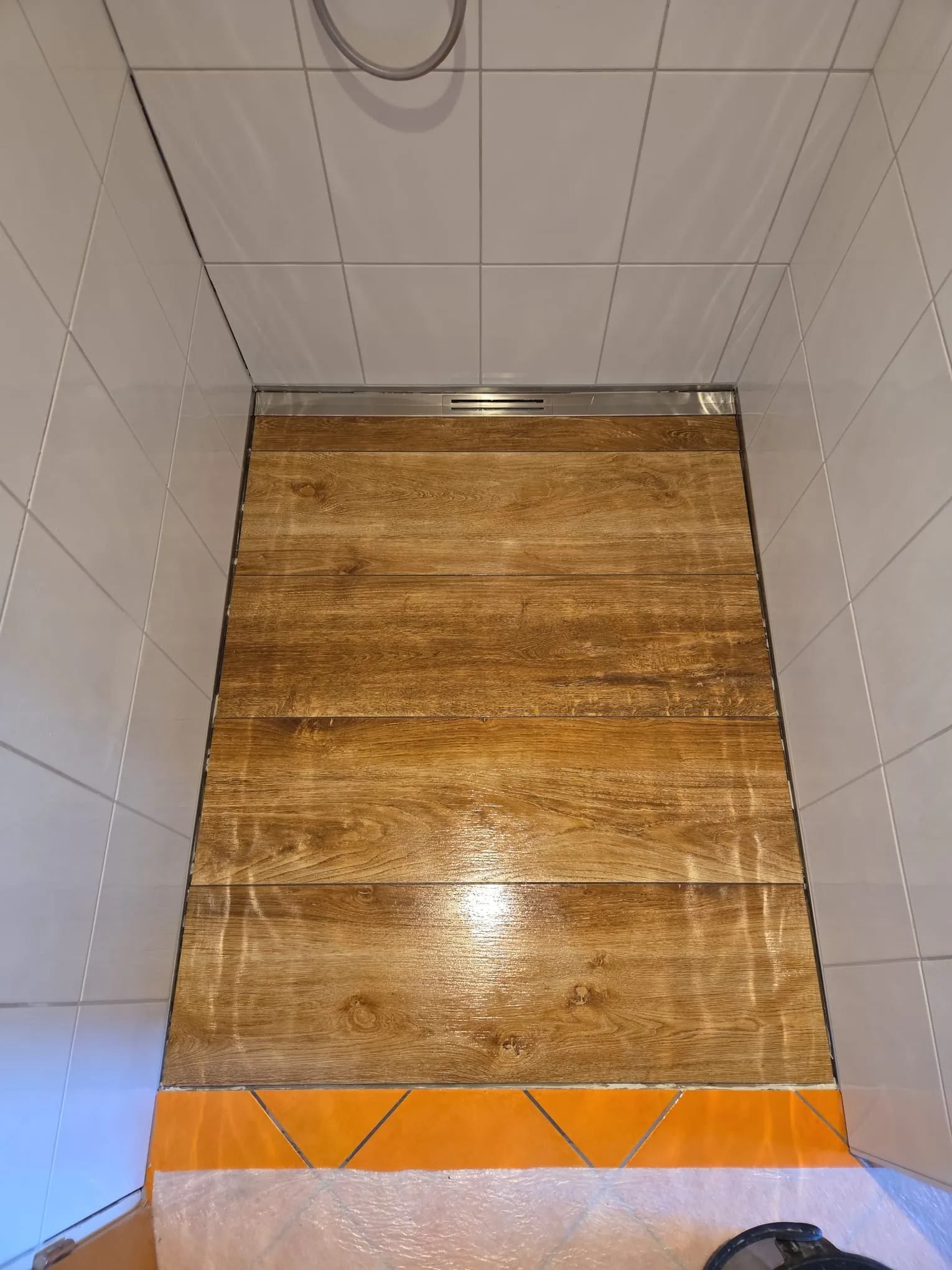 Bodenebene Dusche in Holzoptik mit sauberem Linienablauf – Detailaufnahme